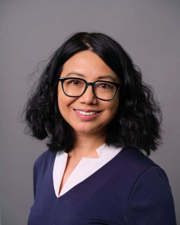Michelle Chen, Ph.D. in a studio portrait wearing a navy outfit and glasses